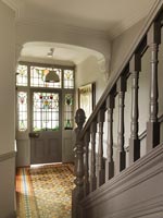 Classic hallway with stained glass windows in front door and period details 