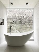 Freestanding bath next to large picture window in contemporary bathroom 