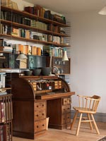 Wooden bureaux in study with book shelves 