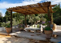 Rustic pergola with reed canopy over outdoor seating area