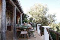 Rustic veranda with large dining table laid for lunch in summer 