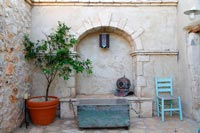 Courtyard garden with furniture and antique diving helmet as an ornament 