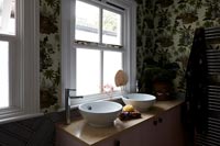 Patterned wallpaper and double sinks in modern bathroom 