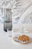 Water jug, glasses and cake on decorative plate - modern kitchen 