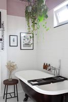 Suspended houseplants above freestanding bath in modern bathroom 