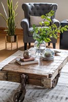 Wooden coffee table made from old farm trolley in country living room 