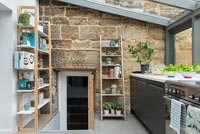 Modern kitchen extension with view of stone house and door 
