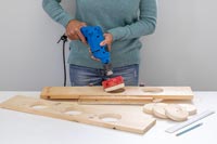 Woman removing the cut piece of wood from newly cut hole