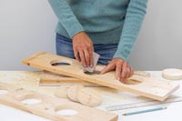 Woman using sandpaper to smooth the edges of the holes cut