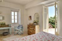 Country bedroom with open French windows to garden