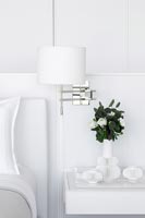 White bedroom furniture and wall mounted lamp detail 