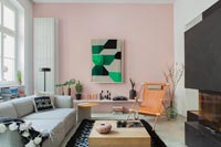 Pale pink painted feature wall with vertical radiator in contemporary living room 
