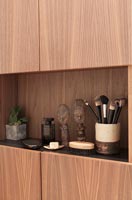 Make-up brushes and carvings on cabinet in modern bathroom 