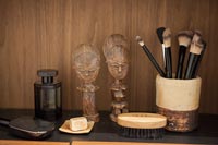 Make-up brushes and carvings on cabinet in modern bathroom 
