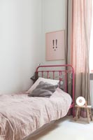 Pink metal framed bed in modern childrens bedroom 