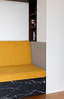 Yellow sofa cushions on built-in seat within alcove 