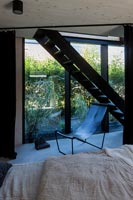 Bedroom with view of contemporary staircase and large windows 