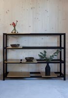 Black shelf unit against wooden wall