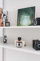Collection of vintage cameras on shelves 