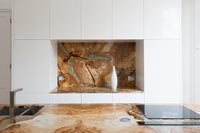 Decorative stone worktop and splashback in modern kitchen 