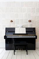 Wall covered in sheet music with piano 
