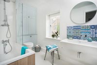 Patterned tiled splashback in white modern bathroom 