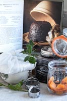 Christmas pudding ingredients and open recipe book on kitchen worktop 