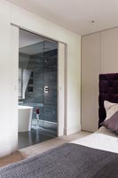 View from bedroom through sliding door to modern en-suite bathroom 