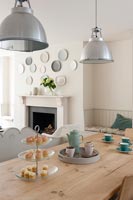 Modern dining room with display of wall mounted plates above fireplace 