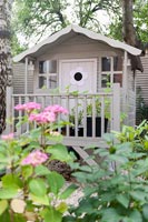 Decorative painted wooden playhouse in garden 