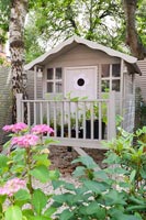 Decorative painted wooden playhouse in garden