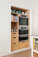 Oven set within shelving unit in modern kitchen 