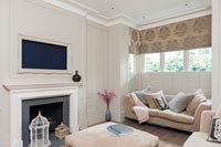 Modern living room with wall mounted flat screen television set within picture frame 