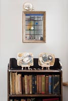 Vintage wooden bookcase with modern painted ceramics on shelf