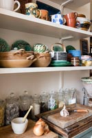 Crockery on shelves above worktop in small kitchen 
