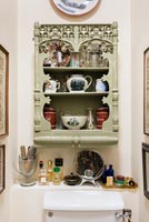 Decorative vintage shelving unit on wall of small bathroom