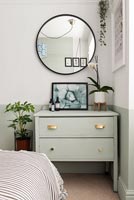 Painted chest of drawers with mismatched handles in modern bedroom 