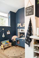 Play kitchen in dark blue painted childrens room 