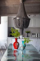 Chandelier over modern glass dining table in kitchen-diner 