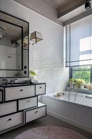 Modern bathroom with vintage sink unit and mirror next to bath
