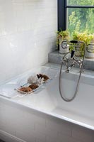 Vintage shower head on mixer taps over bath 