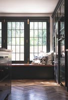 Parquet flooring and built-in window seat in modern kitchen 