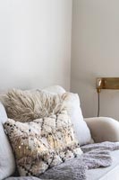 Textured cushion and sheepskin rug on modern sofa 