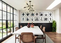 Modern dining room with feature wall of black and white photographs 