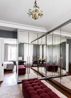 Large mirrored built-in wardrobes in retro style dressing room