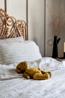 Detail of old teddy bear on bed