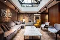 Large modular sofas in modern living room with exposed brickwork walls 