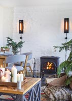 Lit wood burning stove in modern country living space at Christmas 