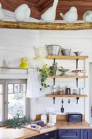 White ceramic birds on wooden perch in modern country kitchen 