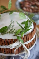 Detail of Christmas cake decorated with cinnamon sticks and green foliage
